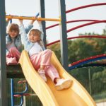 Children are active, smiling. Kids are having fun on the playground