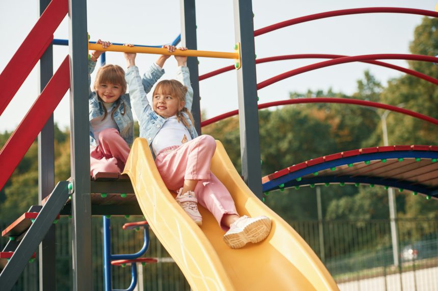 Children are active, smiling. Kids are having fun on the playground