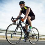 Handsome young man cycling on the road.