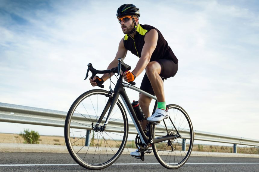 Handsome young man cycling on the road.