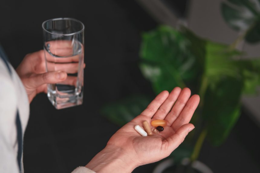 Woman taking various pills, vitamins and health supplements